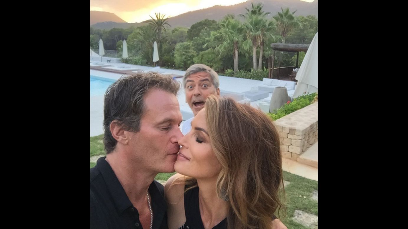 George Clooney photobombs model Cindy Crawford during an intimate moment with her husband, Rande Gerber,<a href="https://instagram.com/p/6vG8KuTLaX/" target="_blank" target="_blank"> in this selfie</a> posted Sunday, August 23. 