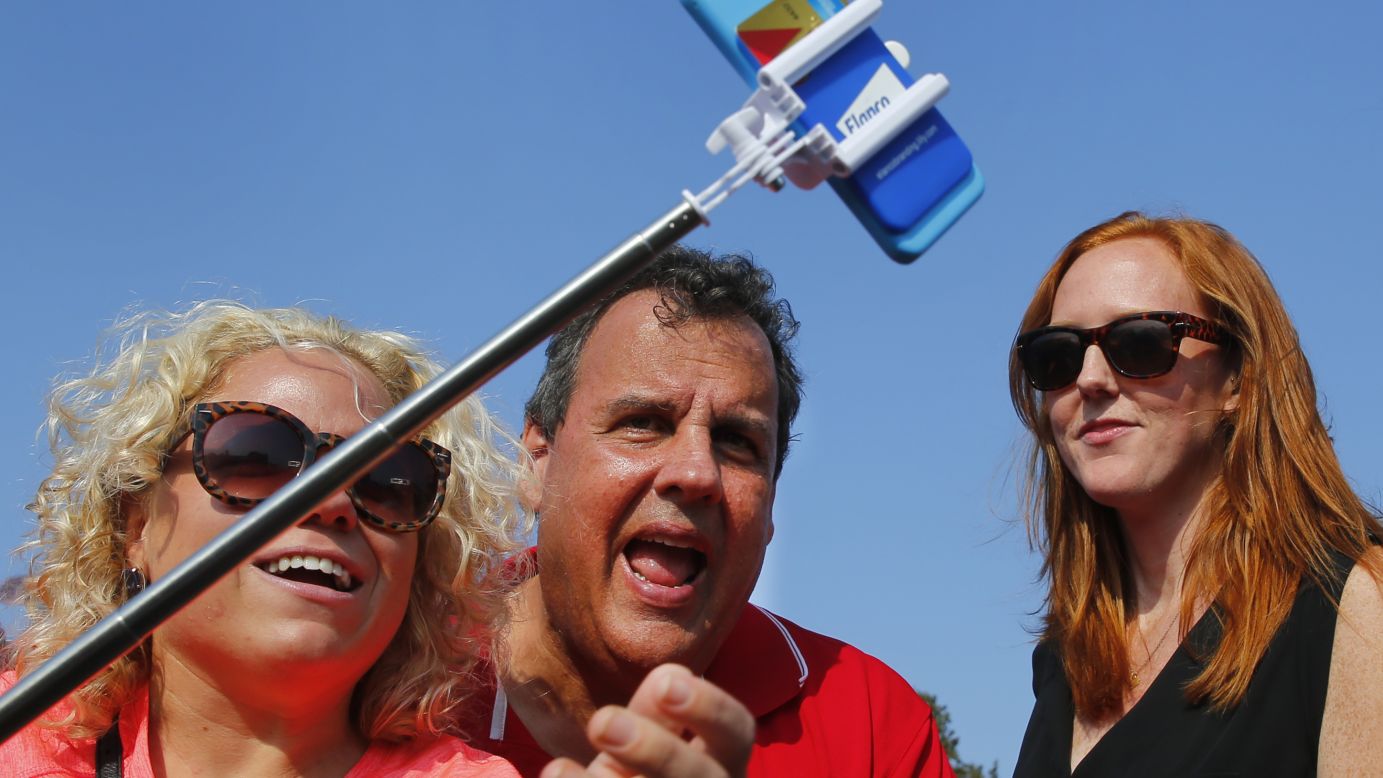 Republican presidential candidate Chris Christie takes a selfie with visitors at the Iowa State Fair on Saturday, August 22, in Des Moines.