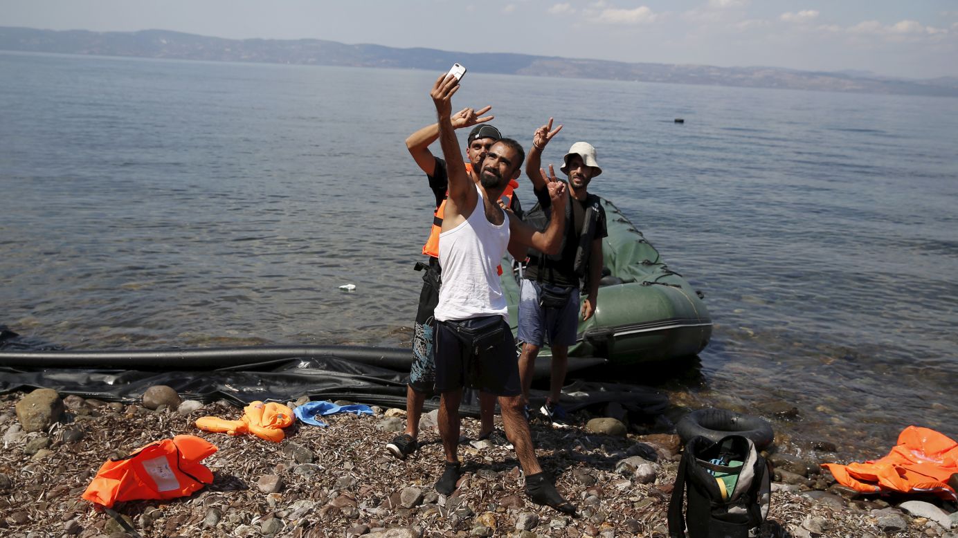 Syrian refugees from Kobani pose for a selfie moment after arriving on a dinghy on the island of Lesbos, Greece, on Sunday, August 23.