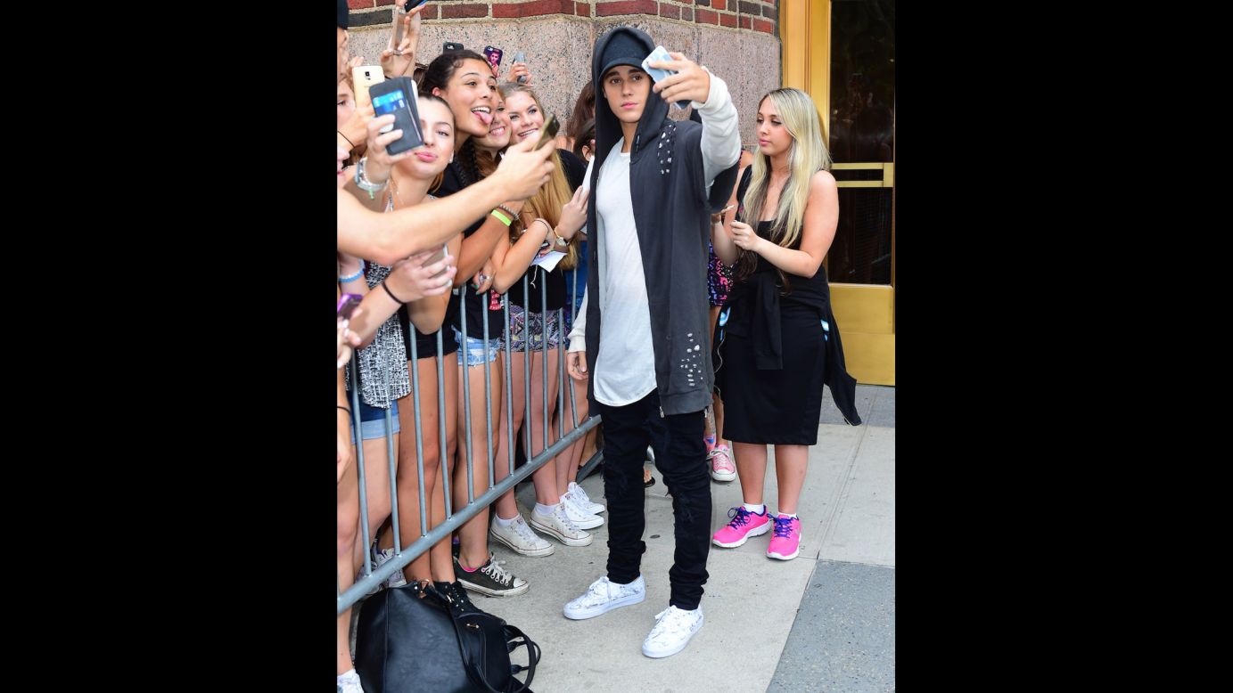 Justin Bieber takes selfies near the  Z100 radio station in New York on Monday, August 24, to promote his new single "What Do You Mean." The pop star took dozens of selfies with screaming fans who waited overnight outside the radio station.