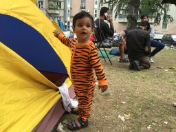 Toddler Ali is in his pajamas outside his family tent near Bristol Park in Belgrade. His family has been on the road for 10 days.