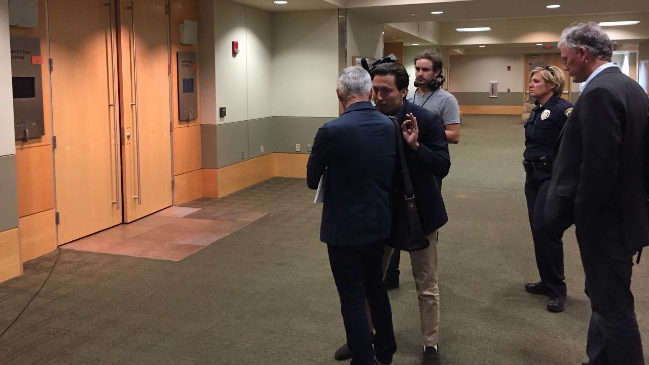 A member of security (center) for presidential candidate Donald Trump speaks to Univision anchor Jorge Ramos (back to camera) outside a Trump presser in Dubuque, Iowa on Tuesday, August 25, 2015. Security removed Ramos from the news conference after Trump told him to "go back to Univsion." Ramos had repeatedly tried to ask a question about immigration. Trump said it was not his turn.