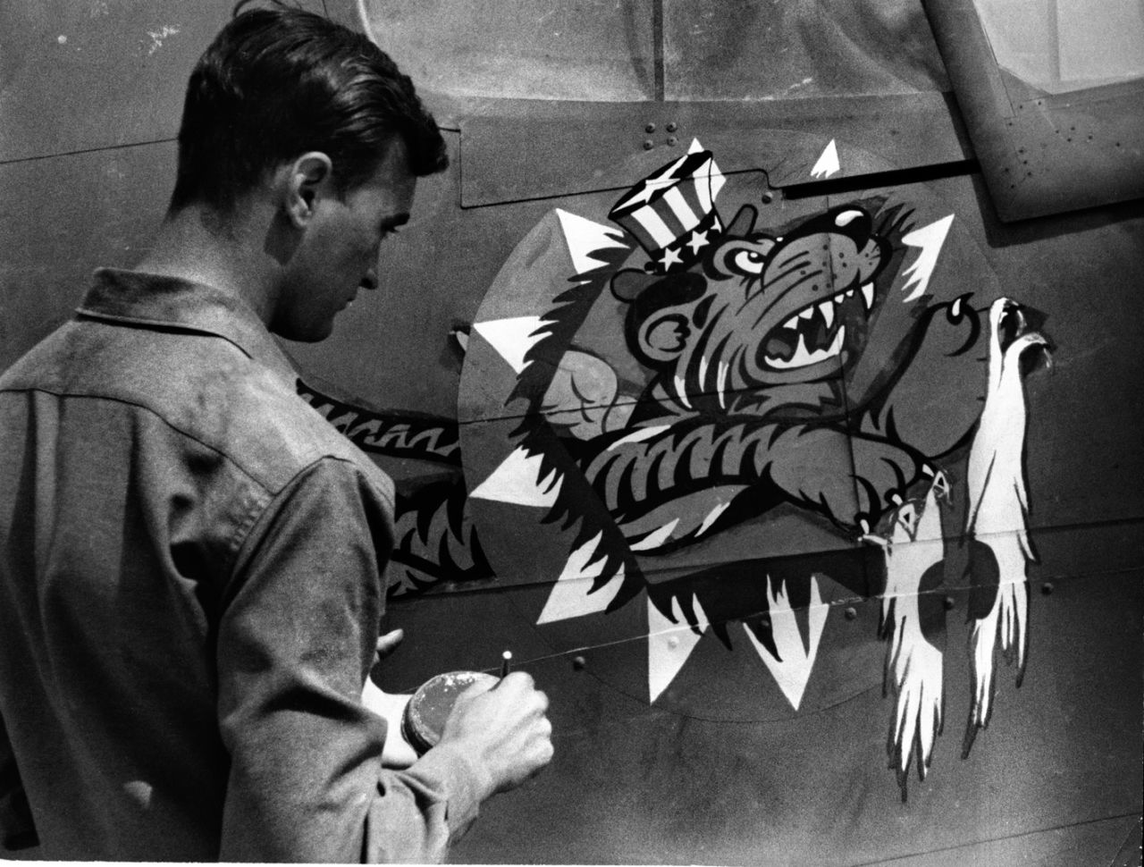 An artist of the China Air Task Force Fighter Command of the United States Army Air Force puts the finishing touches on the insignia of a U.S. plane. The pilots were known as "Flying Tigers."  