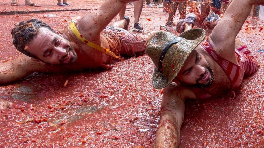 Revellers mock a swim in tomato pulp during the annual "tomatina" festivities in the village of Bunol, near Valencia on August 26, 2015. Some 22,000 revellers hurled 150 tonnes of squashed tomatoes at each other drenching the streets in red in a gigantic Spanish food fight marking the 70th annual "Tomatina" battle.    AFP PHOTO / BIEL ALINO        (Photo credit should read BIEL ALINO/AFP/Getty Images)