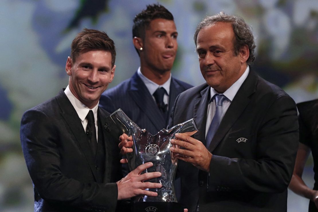 Messi receives his award from UEFA president Michel Platini, while rival Ronaldo looks away.