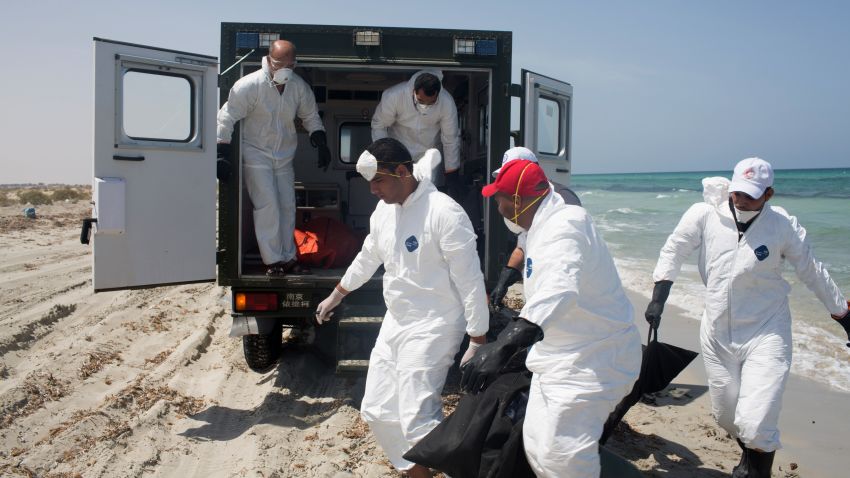 Workers for the Red Crescent carry the body of a dead migrant, in a black body bag, to a nearby truck, at the waterfront in Zuwara, about 105 kilometers (65 miles) west of Tripoli, Libya, Friday, Aug. 28, 2015. Two ships went down Thursday off the western Libyan city, where Hussein Asheini of the Red Crescent said over 100 bodies had been recovered. About 100 people were rescued, according to the Office of the U.N. High Commissioner for Refugees, with at least 100 more believed to be missing. (AP Photo/Mohamed Ben Khalifa)