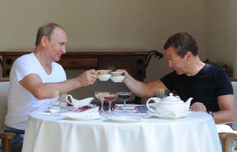Putin, left, and Prime Minister Dmitry Medvedev jokingly toast at a lunch during a meeting at the Black Sea resort in Sochi, Russia, on Sunday, August 30. 
