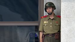 A North Korean soldier looks toward the South side while a group of foreign veterans who fought for South Korea during the 1950-53 Korean War and their relatives visit the truce village of Panmunjom in the Demilitarized Zone (DMZ) dividing the two Koreas on July 28, 2015. The veterans from Canada, the United States and Colombia were invited by a South Korean church group to mark the 62nd anniversary of the signing of an armistice accord that ended the war on July 27, 1953. AFP PHOTO / JUNG YEON-JE (Photo credit should read JUNG YEON-JE/AFP/Getty Images)