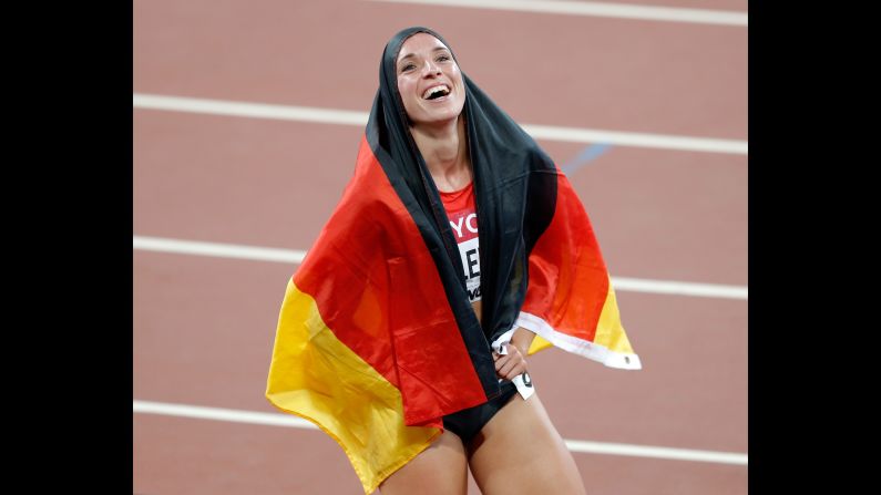 Cindy Roleder wraps the German flag around her Friday, August 28, after she won silver in the 100-meter hurdles at the World Championships. Jamaica's Danielle Williams won the event.