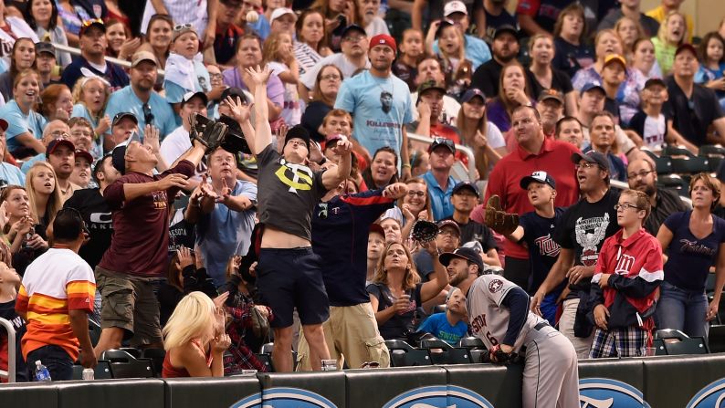 Fans in Minneapolis reach for a foul ball during a Major League Baseball game on Saturday, August 29.