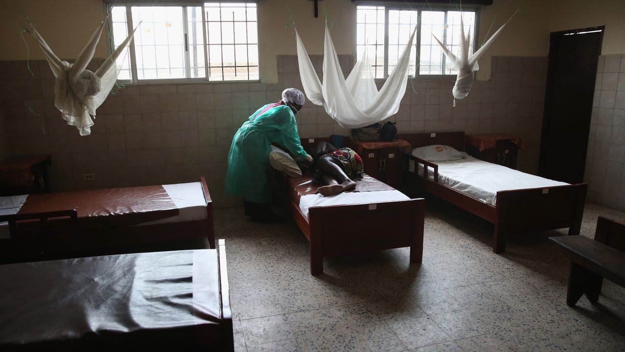 Midwife Maima Johnson hands a newborn girl to mother Cecelia Mensah after delivering the child at the Star of the Sea Health Center in Monrovia, Liberia, in early 2015. Midwives and health workers in the clinic have taken extra precautions throughout Liberia's Ebola epidemic to avoid becoming infected.