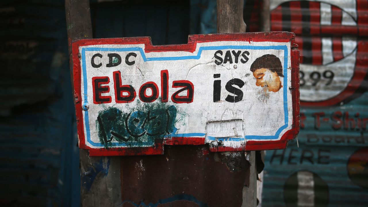 A sign, originally saying "Ebola is Real," hangs defaced in the West Point township in Monrovia, Liberia, in early 2015. Early in the epidemic, many residents of the seaside slum believed the epidemic was a hoax.