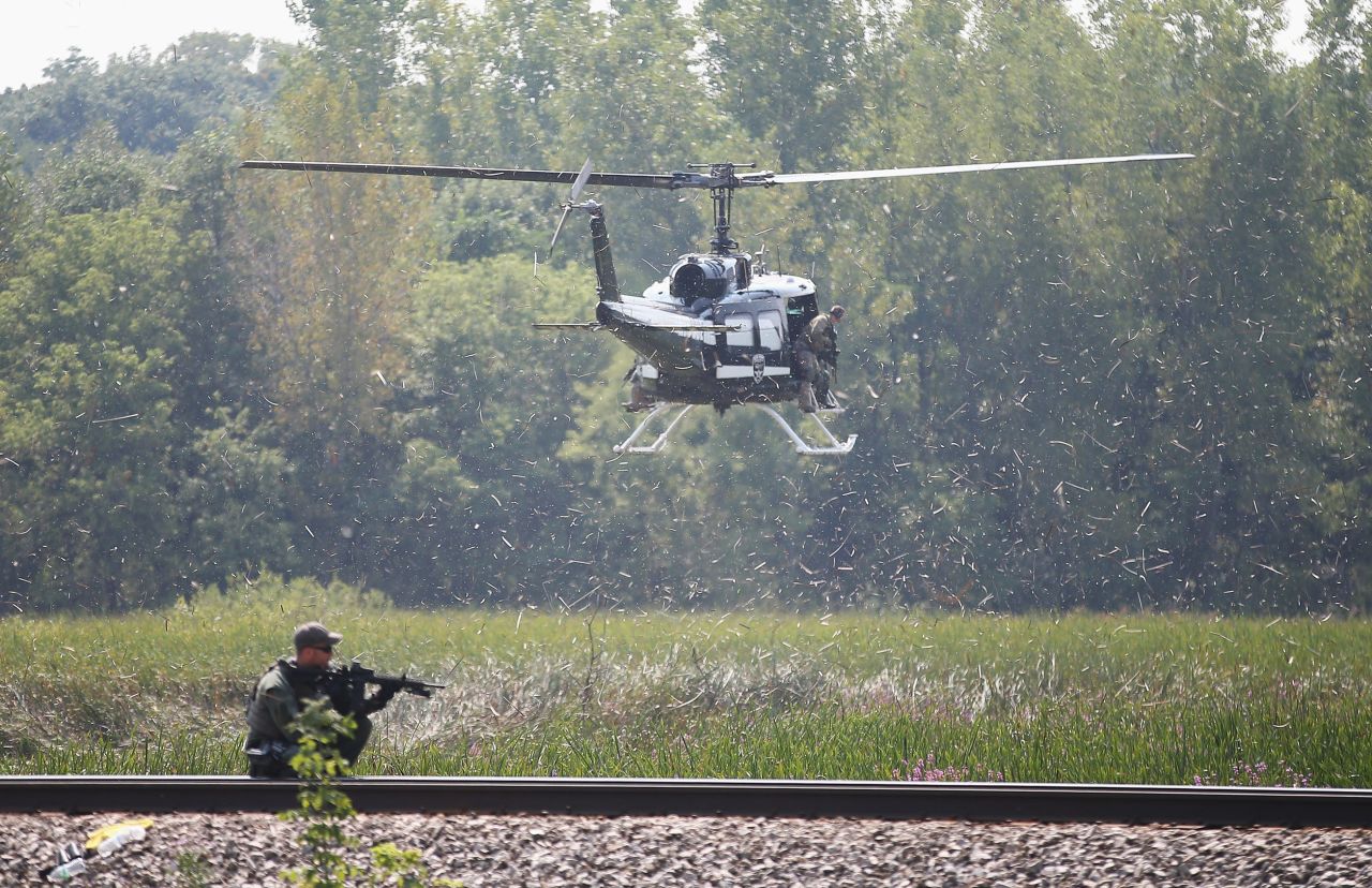 Officers search an area for the suspects.
