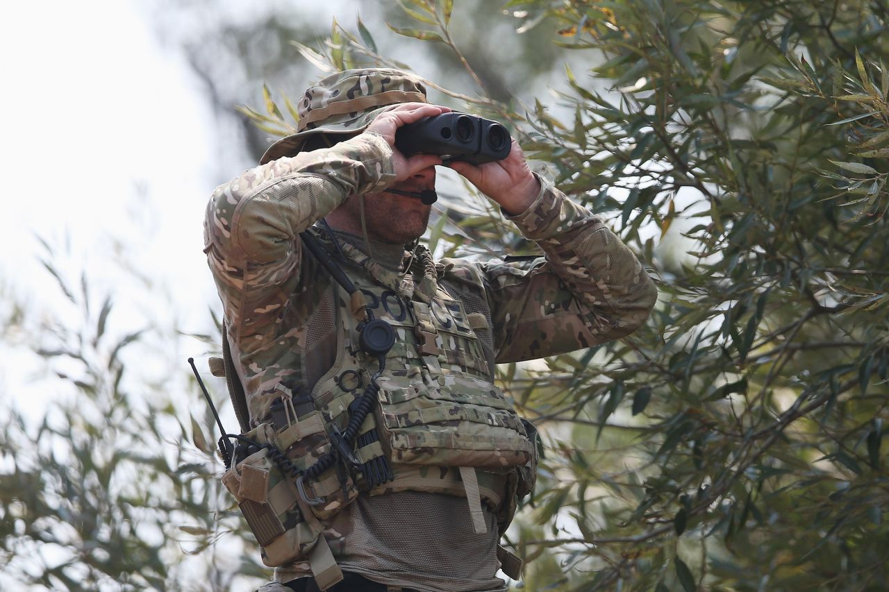 A police officer scans an area for suspects.