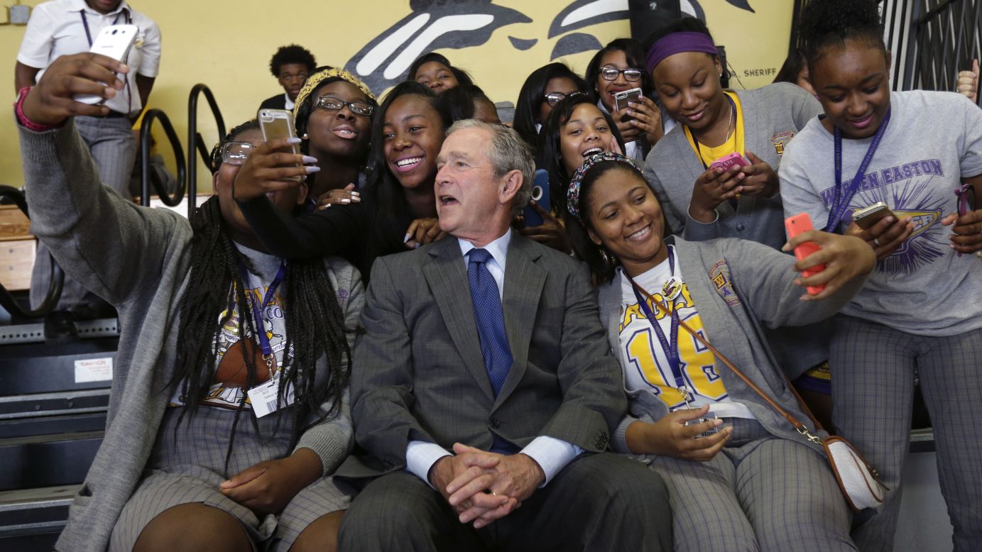 Former U.S. President George W. Bush poses with high school students in New Orleans on Friday, August 28. He was in town to mark the 10th anniversary of Hurricane Katrina.