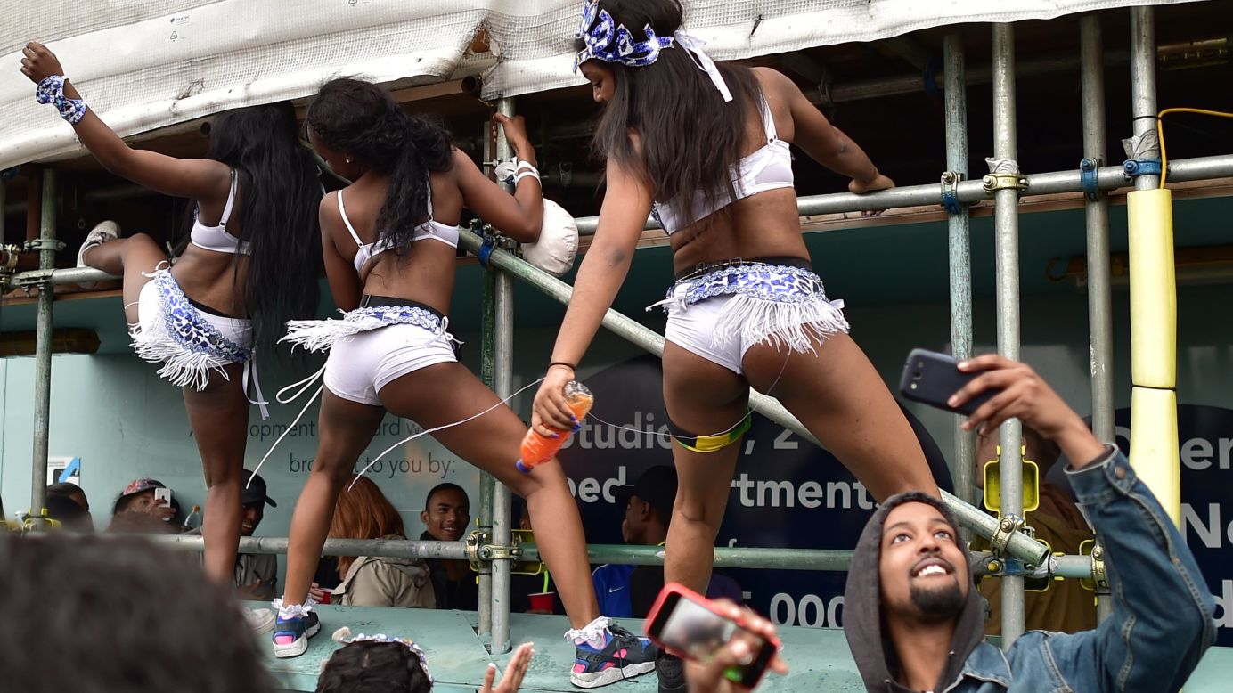 A man takes a selfie as revelers dance in the streets of London during the Notting Hill Carnival on Monday, August 31.
