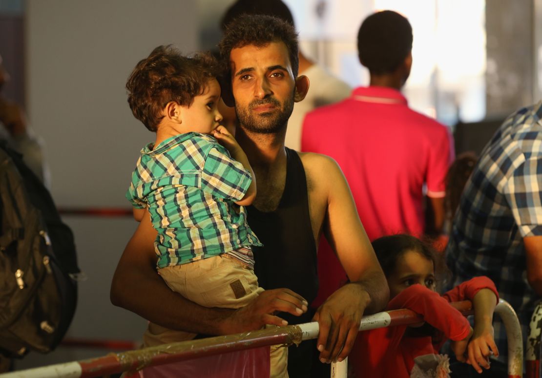 A man from Syria holds one of his children after arriving at the Munich railway station.