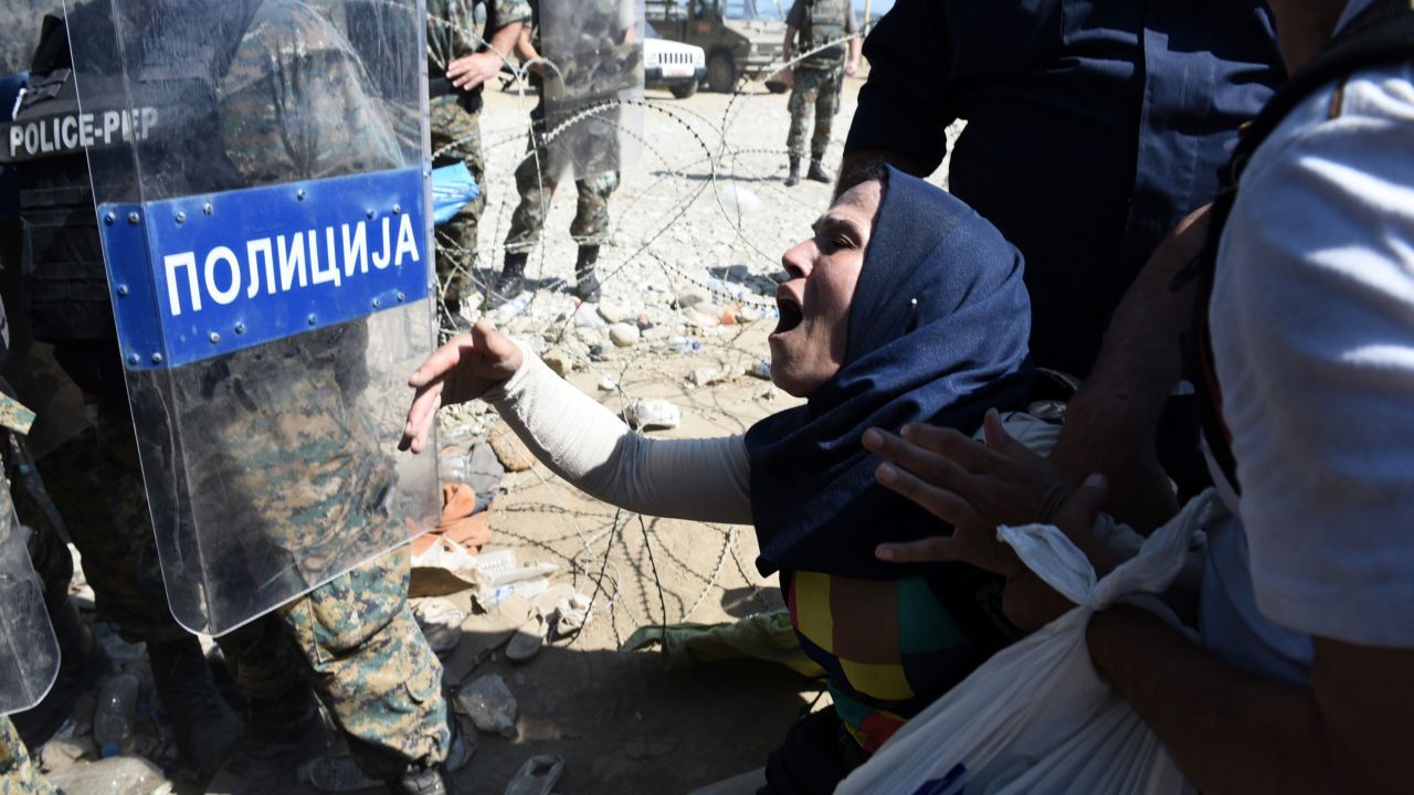 A migrant shouts at Macedonian police officers while trying to cross Greece's northern border into Macedonia. About 1,500 migrants were waiting to cross the border.