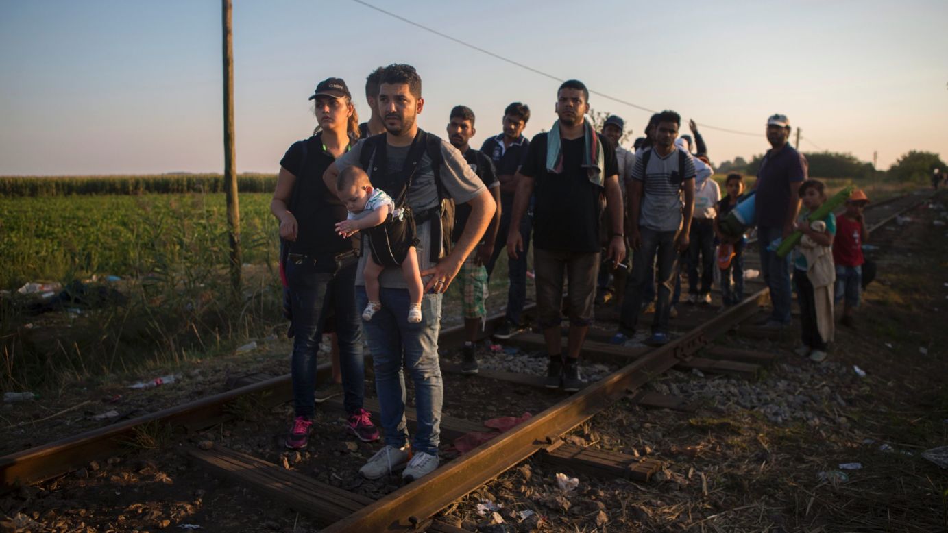 Syrian refugees walk across railways tracks next to the Serbian town of Horgos to cross the border and enter Hungary.