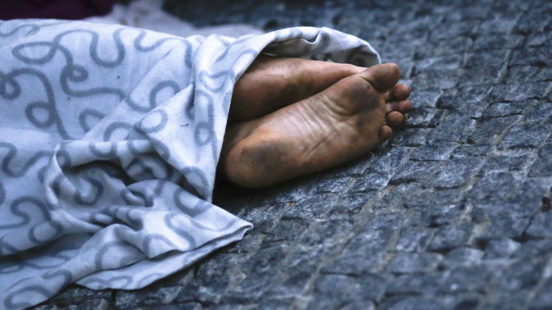 A migrant sleeps on a sidewalk in Berlin near the reception center for refugees and asylum seekers.