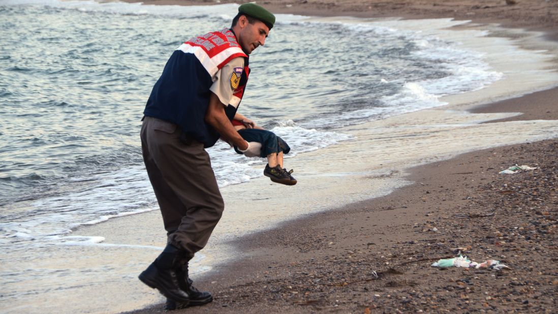 An officer in Bodrum, Turkey, carries Alan's body away from the shore on September 2, 2015.  The child was one of 12 refugees who drowned during a failed attempt to sail to the Greek island of Kos.