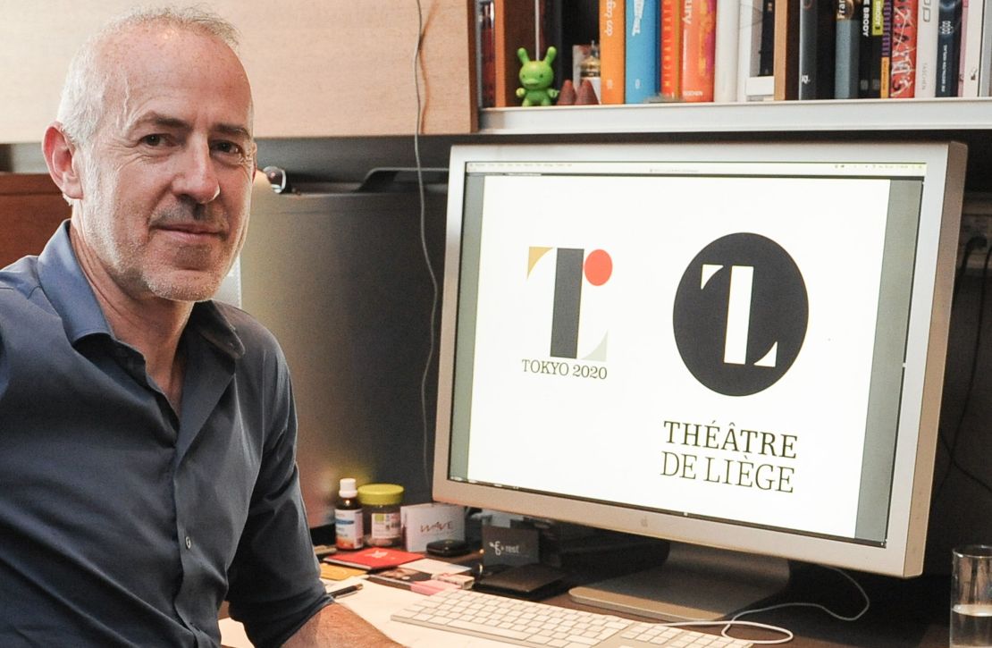 Belgian designer Olivier Debie  poses with Tokyo's 2020 Olympic emblem and the logo of the Theatre de Liege. 