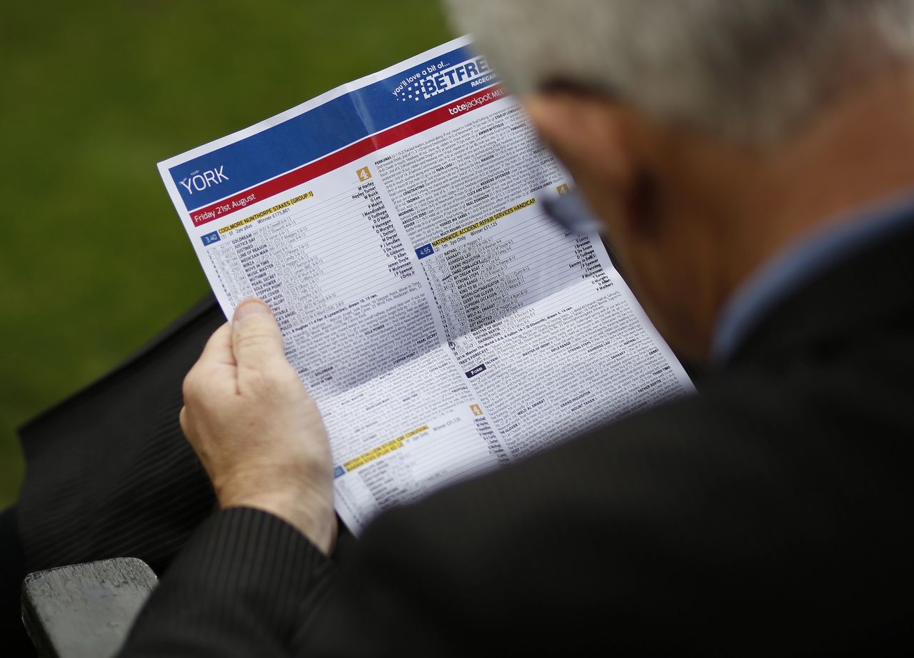 YORK, ENGLAND - AUGUST 21: A racegoer checks the form at York racecourse on August 21, 2015 in York, England. (Photo by Alan Crowhurst/Getty Images)