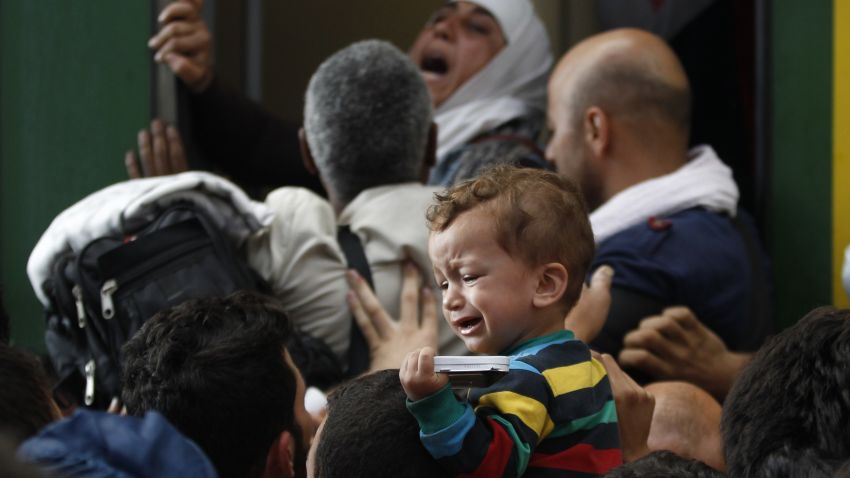 A young child cries as hundreds of migrants try to board a train at the Keleti Railway Station in Budapest, Hungary, Thursday, September 3, 2015.