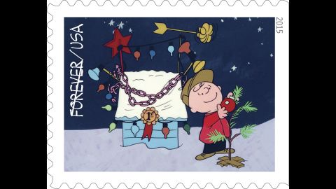 Charlie Brown decorates his tree by the prize-winning lights on Snoopy's doghouse. 