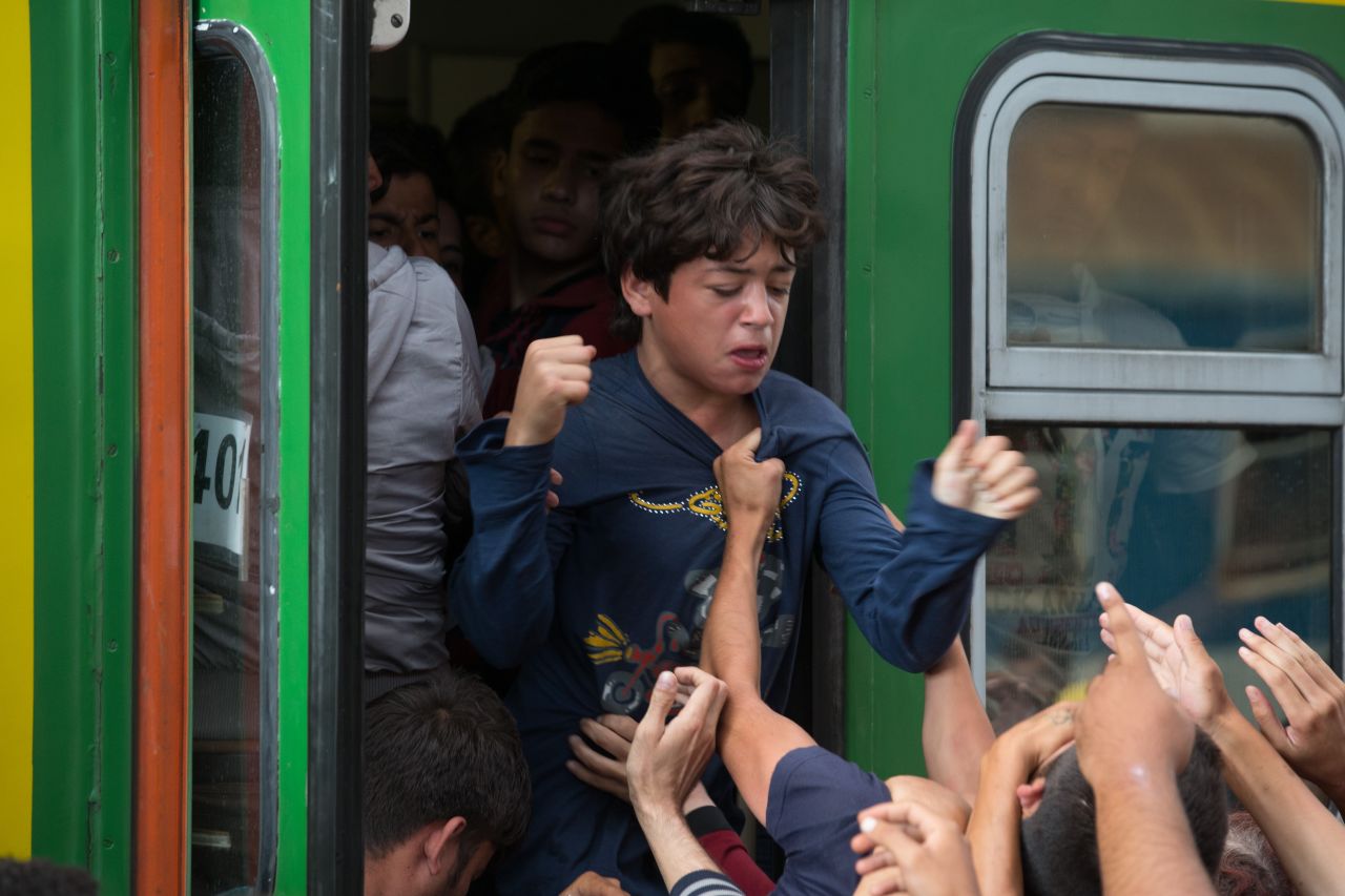 Migrants clamor at the doors of a train carriage in Keleti station.