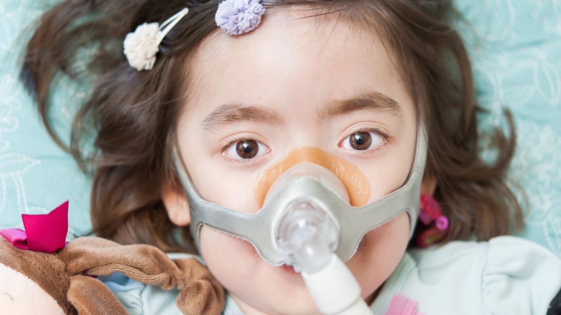 A pressurized mask pumps air into Julianna's lungs. An incurable neurodegnerative disease has attacked the nerves that control her muscles, including those that control her breathing.
