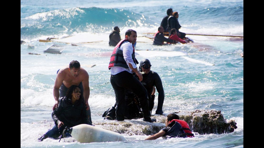 Rescue workers help a woman after a boat carrying migrants sank off the island of Rhodes, southeastern Greece.