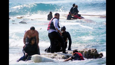 Local residents and rescue workers help migrants from the sea after a boat carrying them sank off the island of Rhodes, Greece, in April 2015.