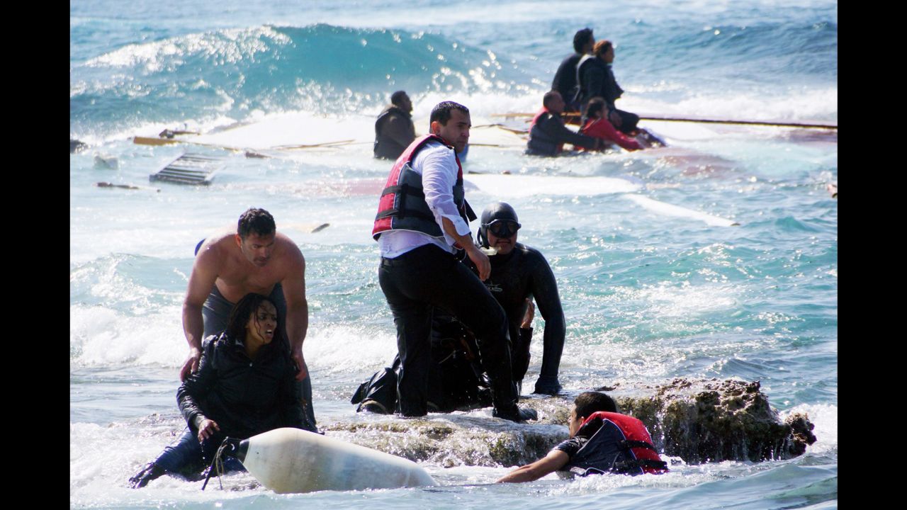 Rescue workers help a woman after a boat carrying migrants sank off the island of Rhodes, southeastern Greece.