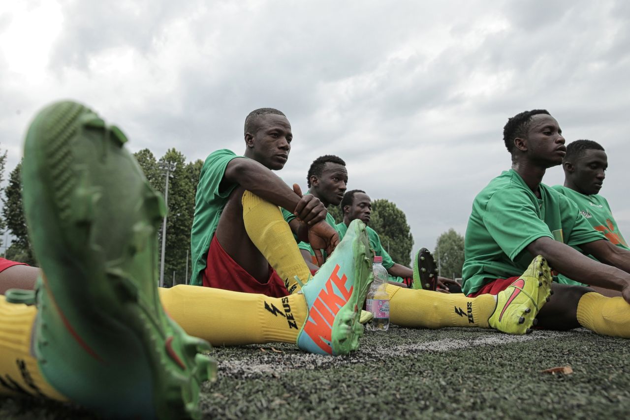 Malian refugee Aboudala Dembele (C), rests with teammates at half-time during the match against Guinea as part of the "Balon Mundial" football tournament for migrants and foreigners, on June 13, 2015 in Turin.