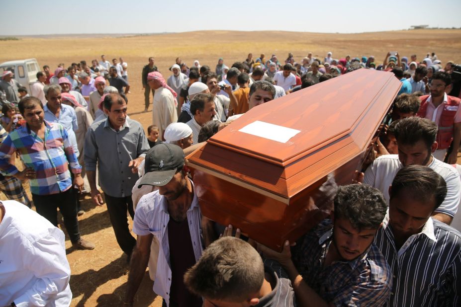 People carry a coffin during the funeral for Alan, Galip and the boys' mother, Rehen, in Kobani, Syria, on Friday, September 4, 2015. Alan's father brought their bodies back from Turkey for burial in the city they had fled.