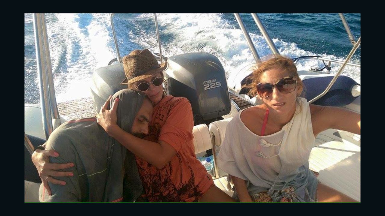 Sandra Tsiligeridou (C) cradles Syrian refugee Mohammed Besmar after rescuing him from the Aegean Sea.