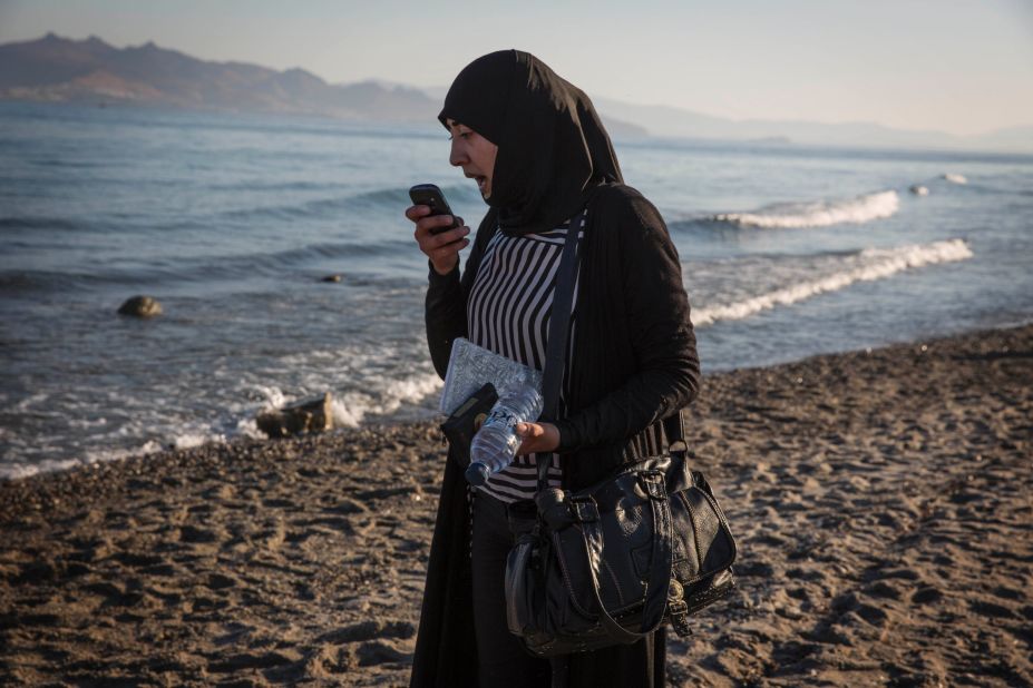 A Syrian woman speaks on the phone while clutching her documents that have been wrapped in plastic to keep them dry during her journey to Kos on August 31.