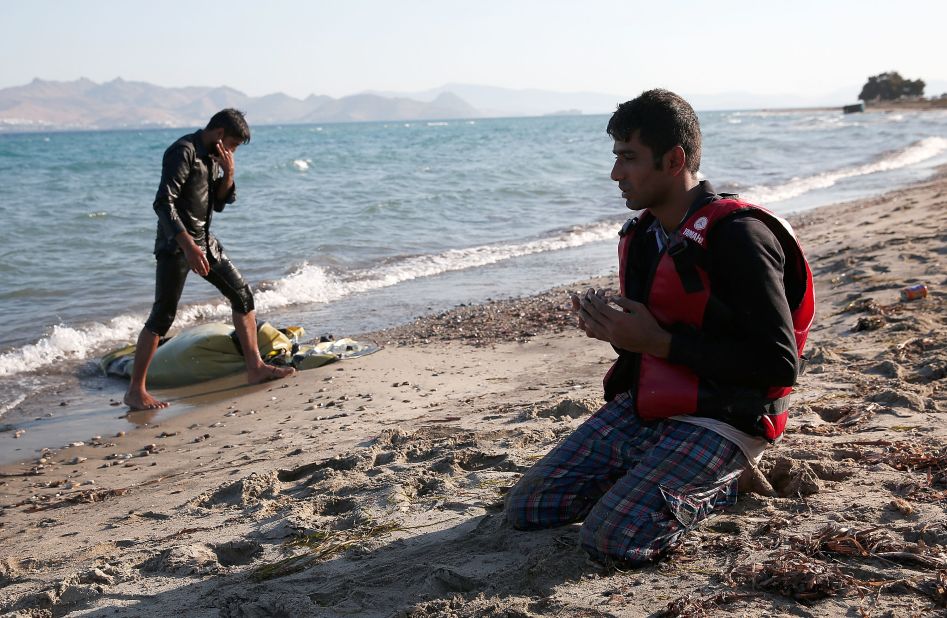 A  Pakistani man prays on the beach after safely completing his journey from Turkey to Kos on August 29.
