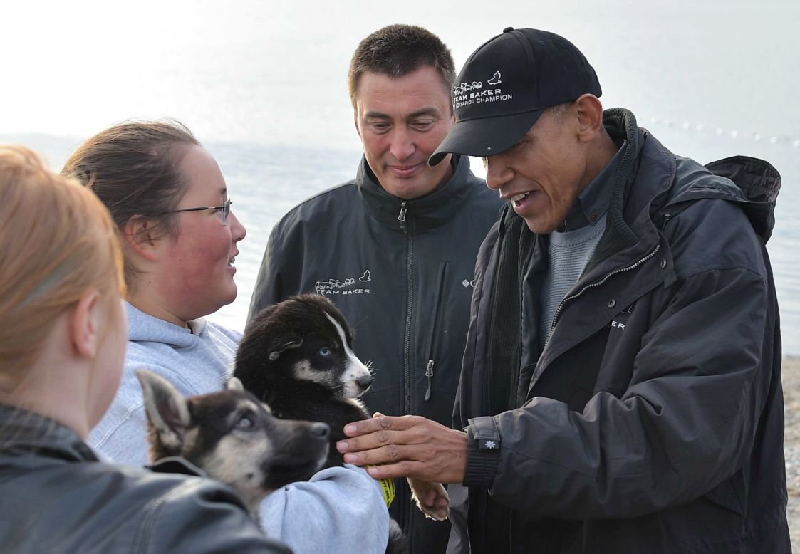 U.S. President Barack Obama says hello to  puppies belonging to musher John Baker (second from the right) in Kotzebue, Alaska, on September 2, 2015. 