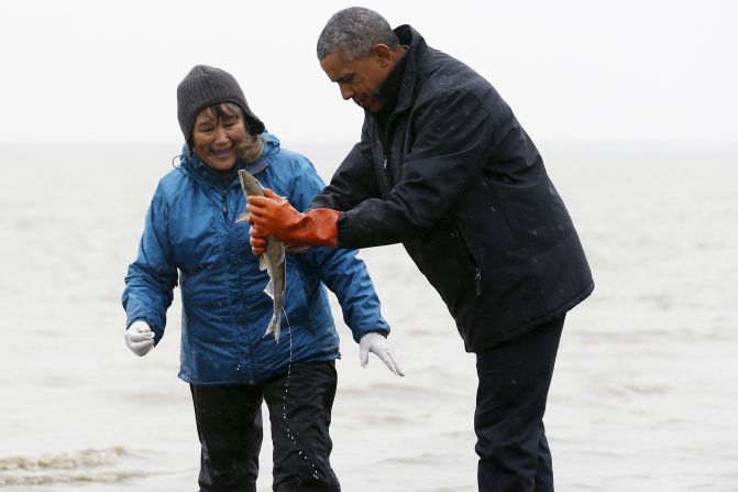 A fish apparently spawns, relieving itself on U.S. President Barack Obama as the latter meets a traditional fisherman on the shore of the Nushagak River in Dillingham, Alaska, on Tuesday, September 2.