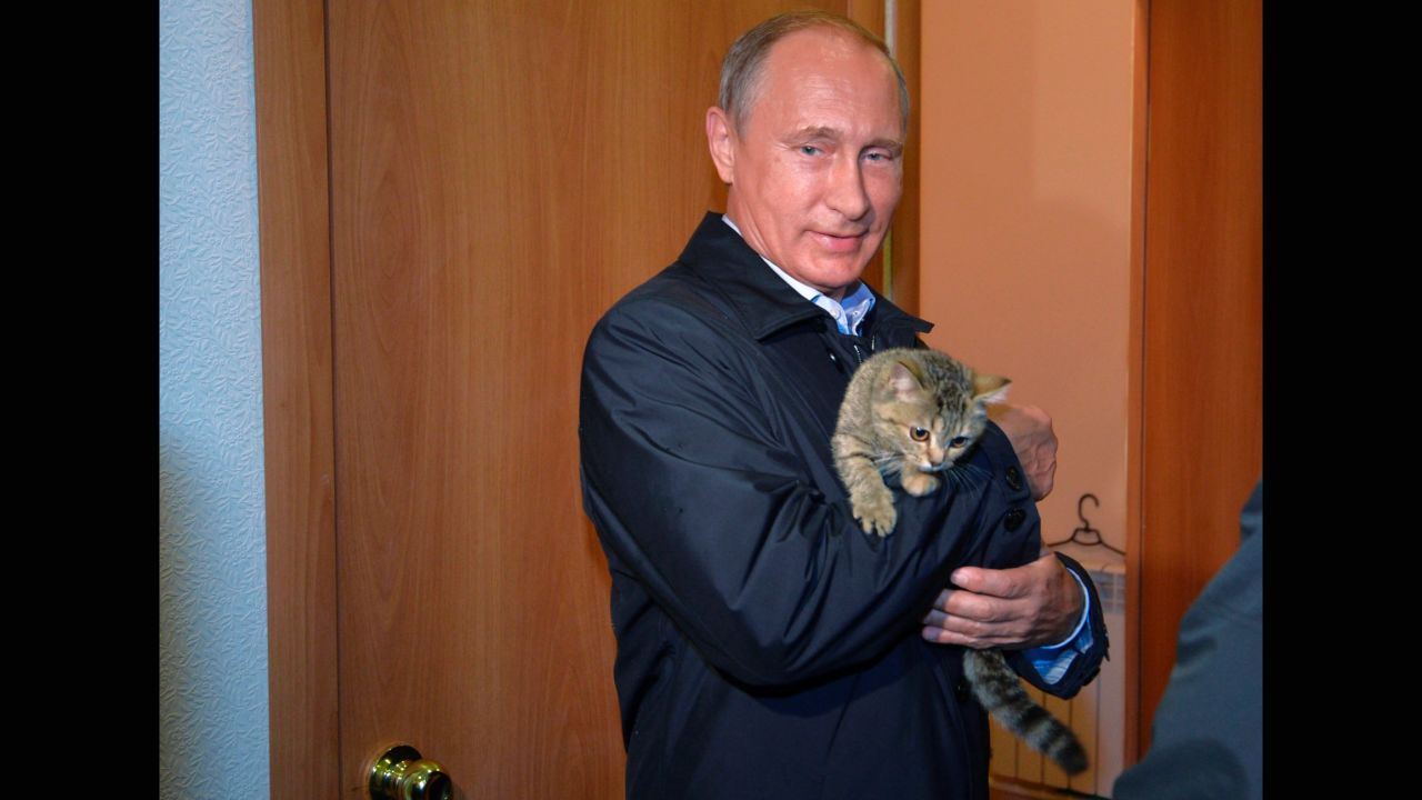 Putin holds a cat as he inspects housing built for victims of wildfires in the village of Krasnopolye, in a region in southeastern Siberia, Russia, on Friday, September 4.
