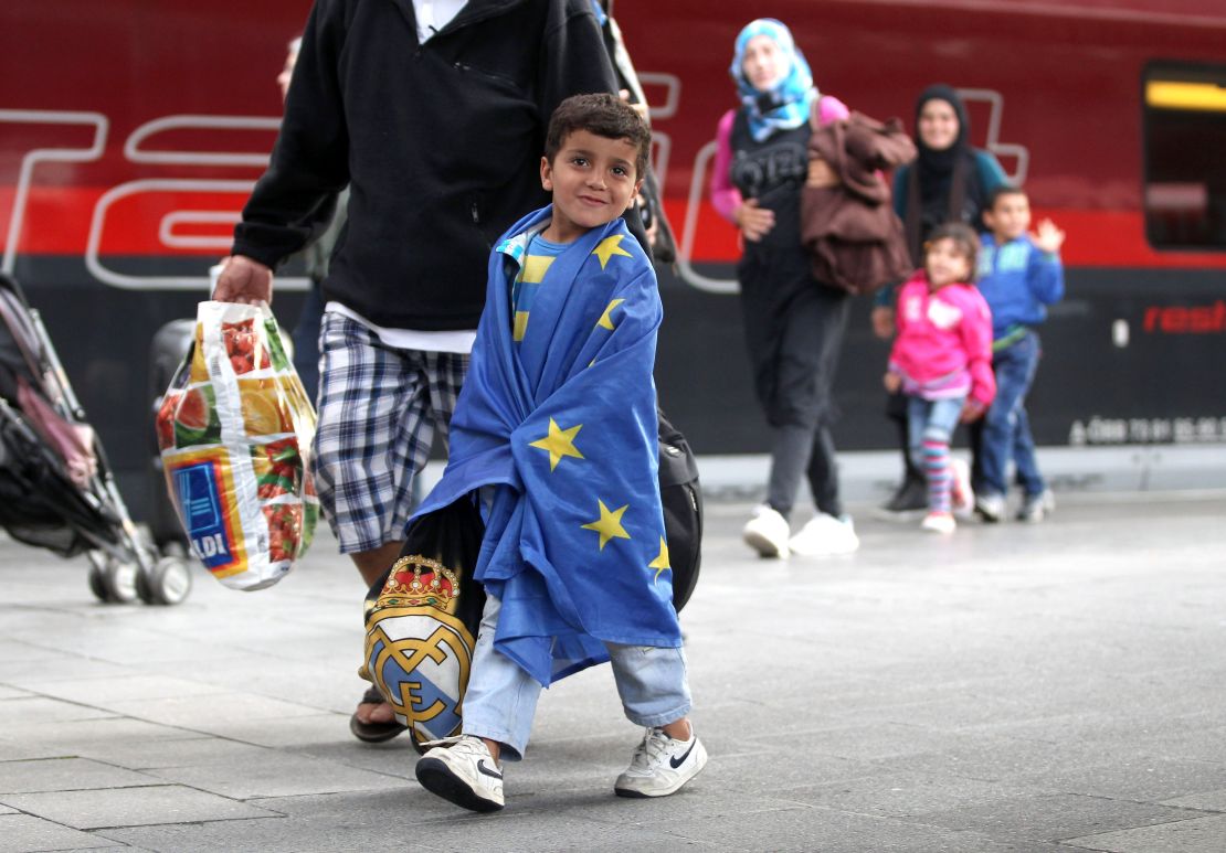A migrant boy wrapped in an EU flag arrives in Munich, Germany, in 2015.