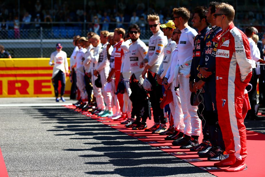 Drivers stand to attention on the grid as the Italian national anthem is played before the action on the track gets under way.