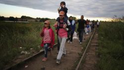 Migrants and refugees cross the border from Serbia into Hungary along the railway tracks close to the village of Roszke on September 6.
