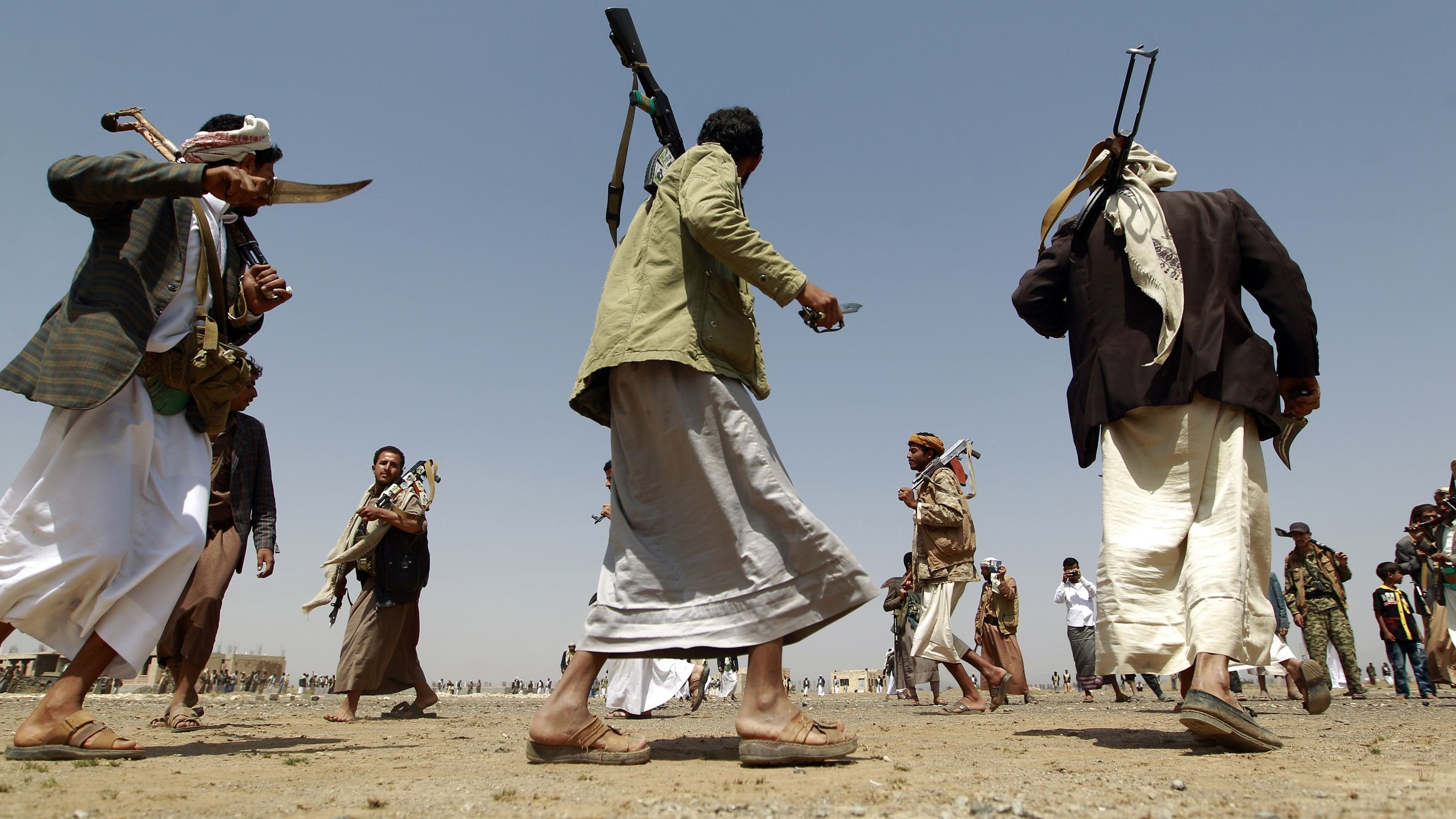 Tribal gunmen loyal to the Shiite-Houthi movement walk holding their weapons during a gathering against the Saudi-led intervention in the country in the Bani al-Harith area, north of the capital Sanaa, on August 6, 2015.