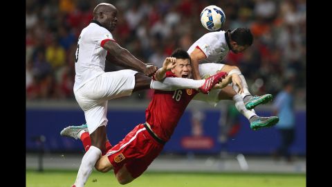 China's Sun Ke, center, is crunched by two Hong Kong players during a World Cup qualifying match in Shenzhen, China, on Thursday, September 3. The match ended scoreless.