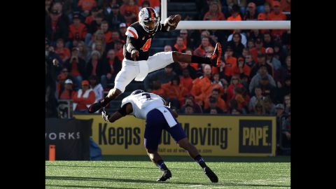Oregon State quarterback Seth Collins leaps over Weber State safety Josh Burton during a college football game in Corvallis, Oregon, on Friday, September 4.
