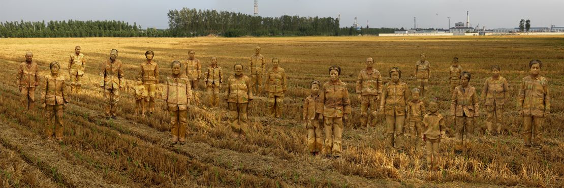 Liu camouflaged 23 residents from one of China's 'cancer villages.' into a rural backdrop. A chemical factory is seen in the distance.