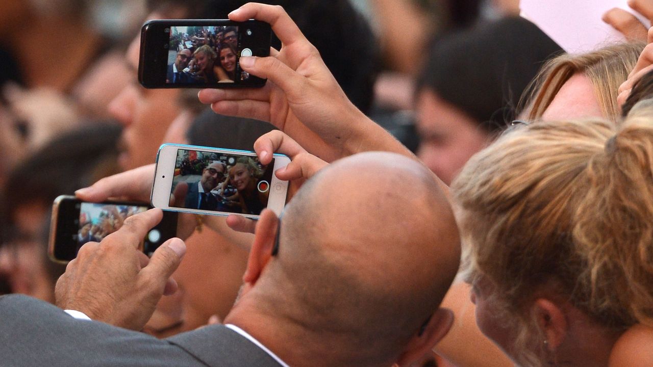 Actor Stanley Tucci poses with fans Thursday, September 3, as he arrives at the Venice Film Festival in Venice, Italy.